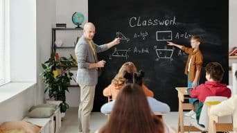 Pizarra de tiza, aula de una clase con alumnos y profesor